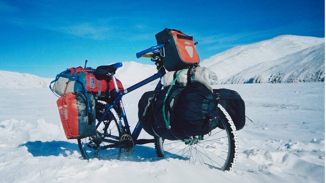 雪に覆われたチベット高地を旅するための荷物を積んだ自転車